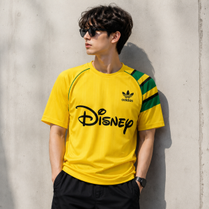 adidas x Brain Dead x Disney World Cup 2026 Retro Soccer Jersey - Yellow & Green 9 Model wearing the adidas Disney Brain Dead retro soccer jersey styled in a streetwear outfit